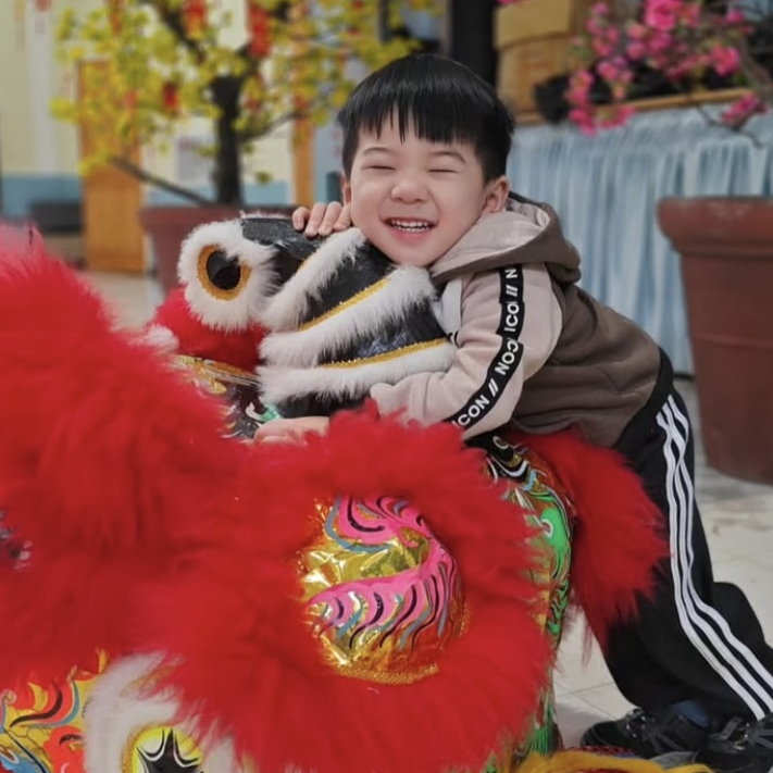 Young Bao Bao Lion performer smiling in costume